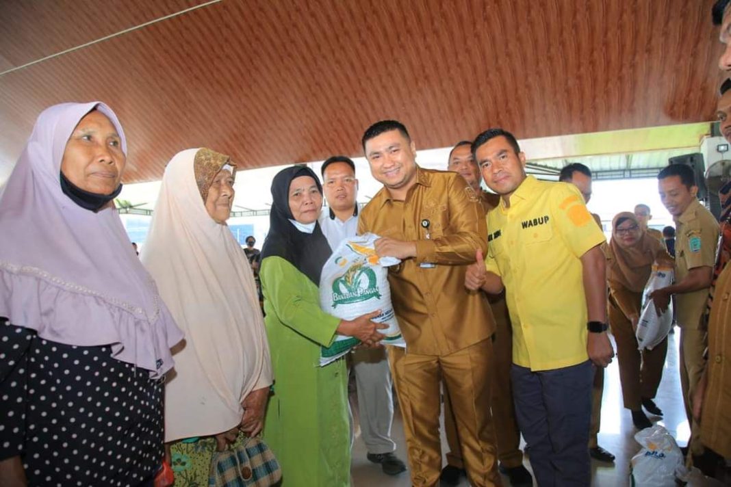 Bupati Labura Hendri Yanto Sitorus menyerahkan bantuan beras kepada salah seorang warga Labura yang termasuk dalam KPM di Pendopo Ranto Simangunsong, Kantor Bupati Labura, Selasa (26/9/2023). (Dok/Kominfo Labura)