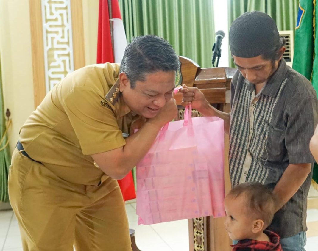 Pj Wali Kota Tebingtinggi Drs Syarmadani MSi menyerahkan bantuan susu kepada warga yang terkena stunting, di Gedung Hj Sawiyah, Jalan Sutomo, Selasa (10/10/2023). (Dok/Kominfo Tebingtinggi)