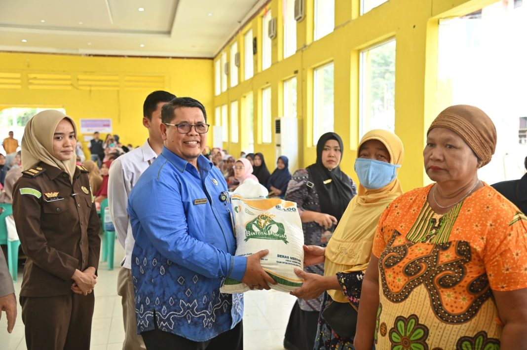 Pemerintah Kota Padangsidimpuan menyalurkan bantuan pangan cadangan beras tahap 2 kepada 2.836 keluarga penerima manfaat. Dalam gambar, Pelaksana harian Sekda Kota H Rahuddin Harahap SH MH mewakili Pj Wali Kota H Letnan Dalimunthe SKM MKes (kiri) sedang menyalurkan bantuan kepada masyarakat di Gedung Adam Malik Padangsidimpuan, Kamis (12/10/2023). (Dok/Kominfo Padangsidimpuan)