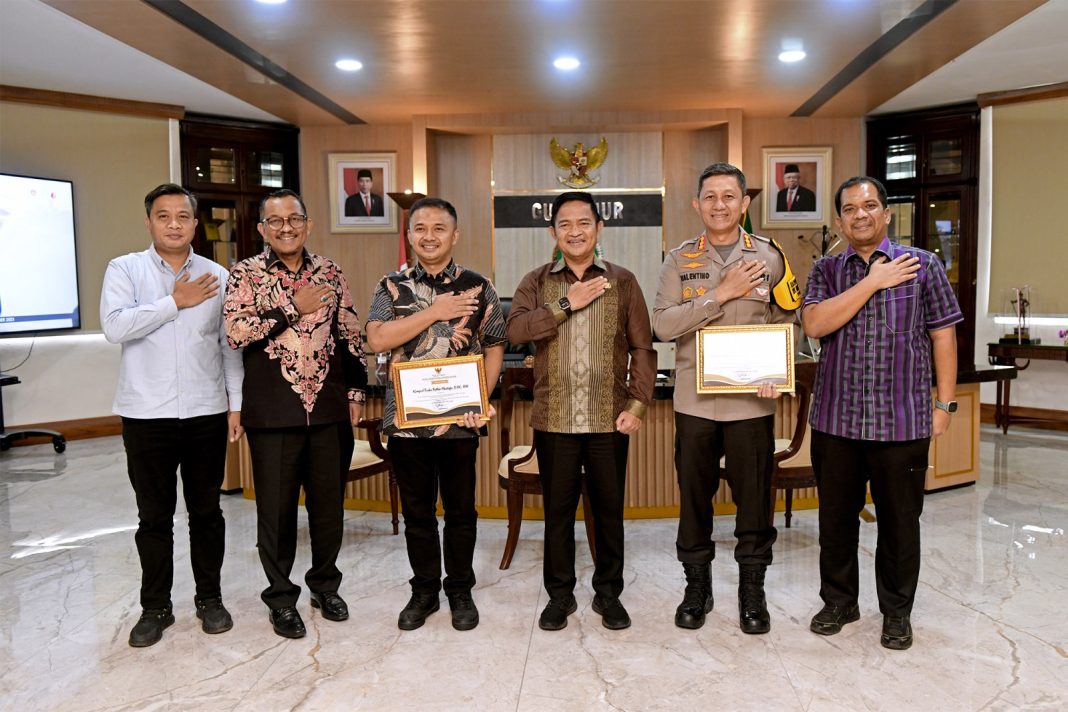 Pj Gubernur Sumut Dr Hassanudin foto bersama seusai memberikan piagam penghargaan kepada Kapolrestabes Medan Kombes Pol Valentino Alfa Tatareda dan Kasat Reskrim Polrestabes Medan Kompol Teuku Fathir Mustafa. (Foto Ist)