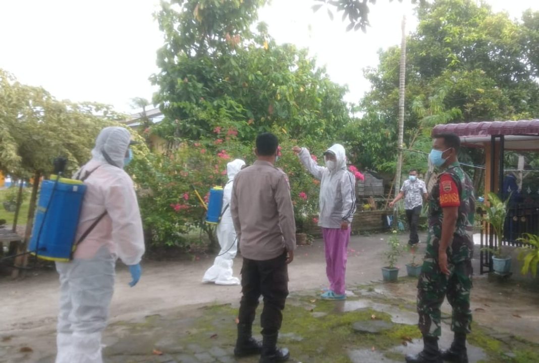 Bhabinkamtibmas Polres Sergai Aiptu Hendra Wiryato bersama Babinsa dan nakes menyemprot malaria di rumah warga dan lingkungan sekitar di Desa Pematang Guntung, Kecamatan Teluk Mengkudu, Jumat (20/10/2023). (Dok/Humas Polres Sergai)