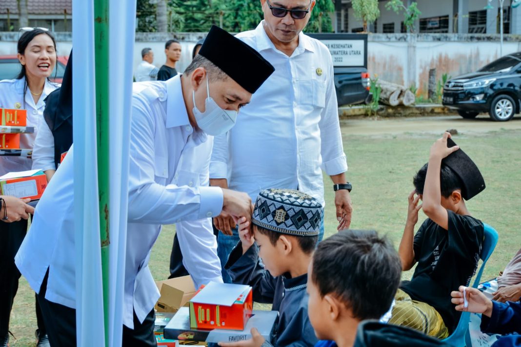 Bupati Batubara Ir H Zahir MAP menyalami anak-anak usai membuka pelayanan kesehatan yang berkolaborasi dengan Pemerintah Provinsi Sumut dalam rangka memperingati Bulan Bakti Kesehatan yang berlangsung di halaman Kantor Camat Sei Suka, Rabu (8/11/2023). (Dok/Kominfo Batubara)