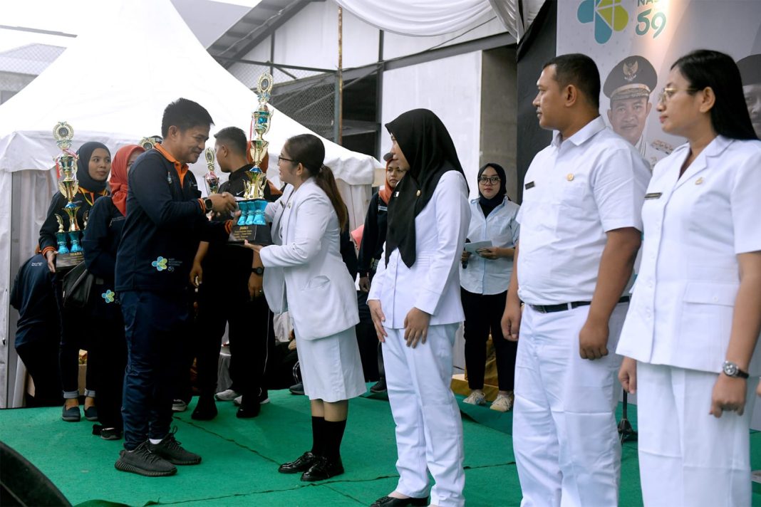 Pj Gubernur Sumut Dr Hassanudin menyerahkan penghargaan kepada para nakes di acara HKN ke-59 tahun 2023 yang diselenggarakan Dinas Kesehatan Provinsi Sumut di Halaman Parkir Belakang Kantor Gubernur Sumut (Eks Medan Club), Jalan RA Kartini Medan, Minggu (19/11/2023).