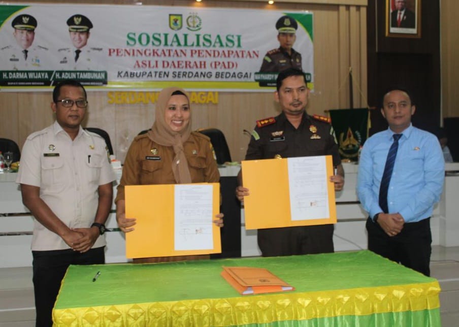 Usai ditandatangani, Kajari Sergai Mayhardi Indra Putra SH MH didampingi Kasi Datun Tulus Yunus Abdi SH MH dan Kepala Bapenda Sergai Sri Rahmayani memperlihatkan nota kesepahaman bersama antara Kejari Sergai dan Pemkab Sergai melalui Bapenda, Selasa (21/11/2023). (Dok/Kejari Sergai)