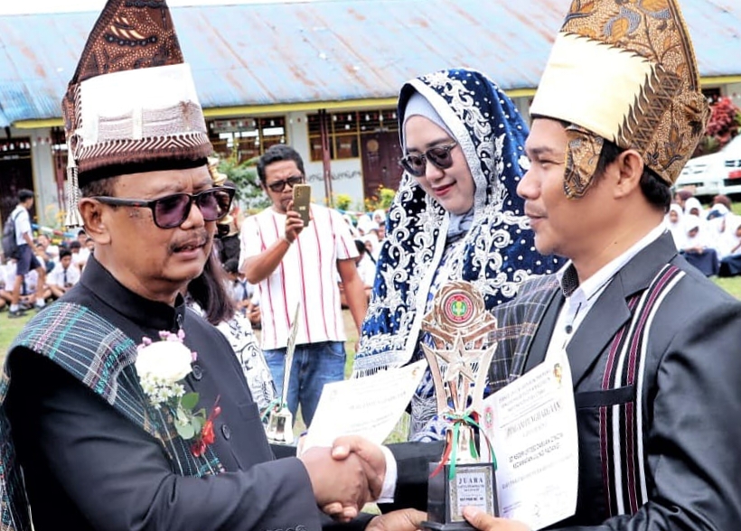 Wakil Bupati Simalungun Zonny Waldi memberikan penghargaan kepada kepala sekolah, guru dan siswa berprestasi saat peringatan Hari Guru Nasional dan HUT ke-78 PGRI di SMP Negeri 1 Gunungmalela, Sabtu (25/11/2023). (Dok/Kominfo Simalungun)