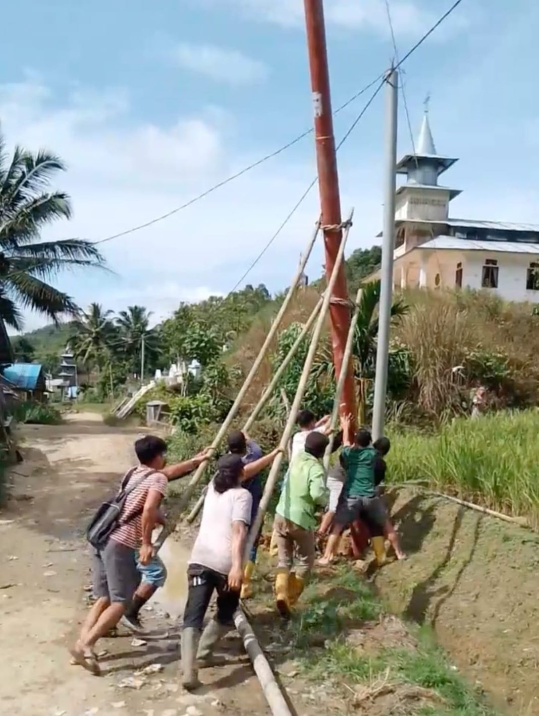 Petugas PLN dibantu masyarakat dalam mendirikan tiang listrik di Desa Hiliwaele II, Kecamatan Botomozoi, Kepulauan Nias. (Dok/PLN)