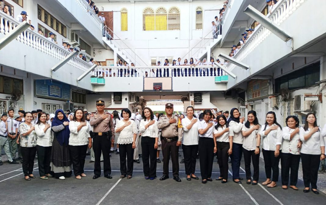 Kapolsek Siantar Timur Iptu Jon H Purba foto bersama guru dan siswa/i di sekolah YP Mars di Jalan Ahmad Yani, Senin (20/11/2023). (Dok/Humas Polres Pematangsiantar)