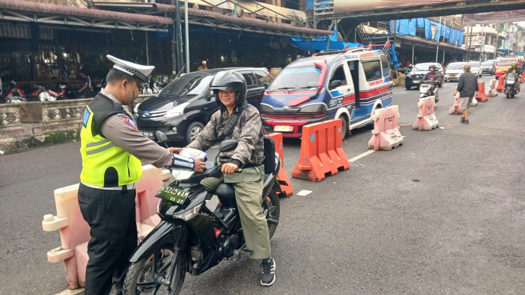 Petugas Sat Lantas Polres Pematangsiantar saat sosialisasi tertib berlalulintas kepada pengendara di kawasan Pasar Horas, Jalan Merdeka, Kamis (2/11/2023). (Dok/Humas Polres Pematangsiantar)