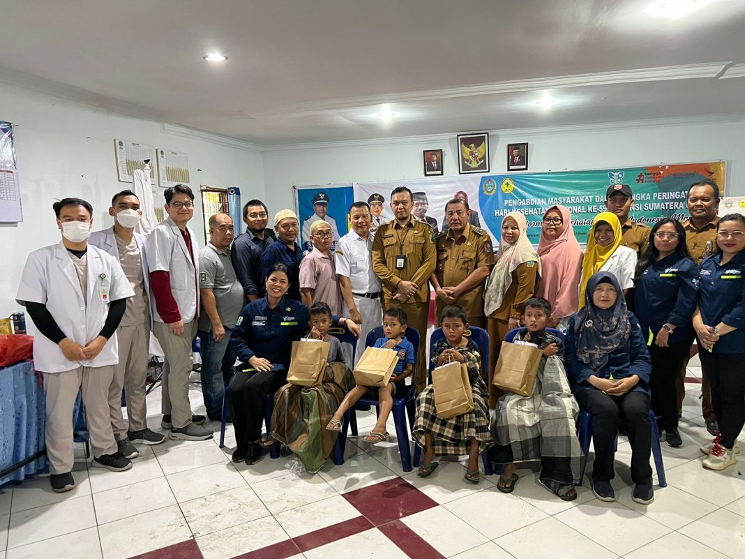 Ketua Panitia HKN RSU Haji Medan drg Anda Siregar foto bersama dengan lainnya di kegiatan pengobatan gratis dan khitanan massal dilaksanakan di Aula Kantor Kepala Desa Lau Dendang, Selasa (14/11/2023). (Foto Dok/Humas RSU Haji Medan)