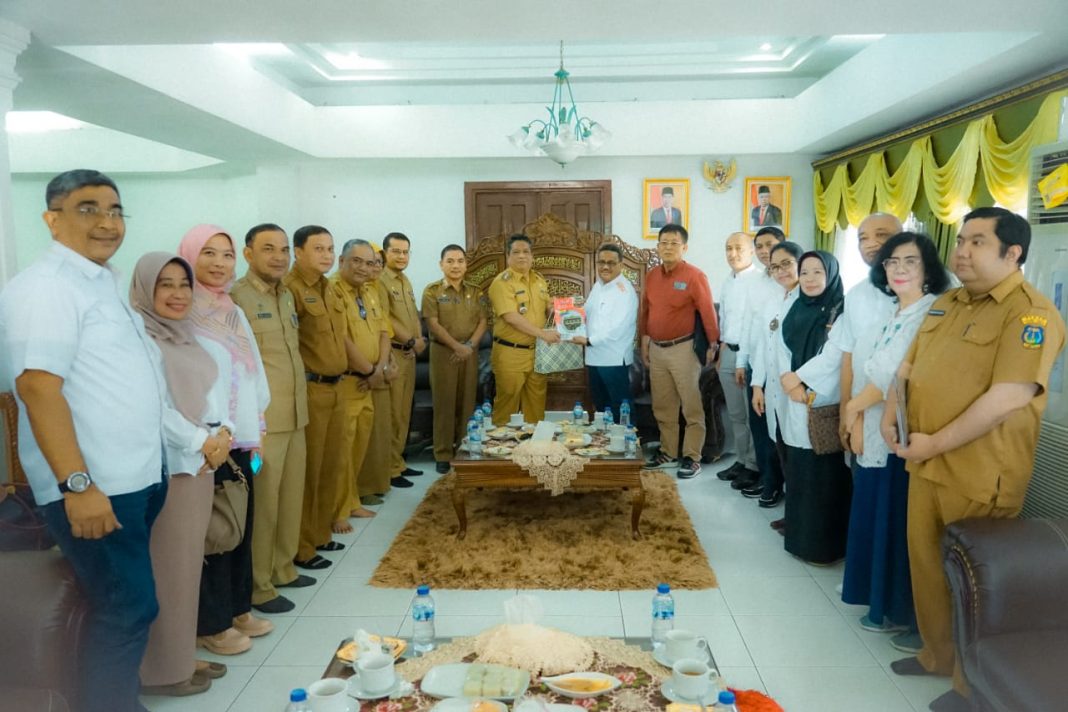 Pj Wali Kota Tebingtinggi Syarmadani foto bersama sekaligus menerima cendramata dari pihak Unimed, Senin (20/11/2023). (Dok/ Kominfo Tebingtinggi)