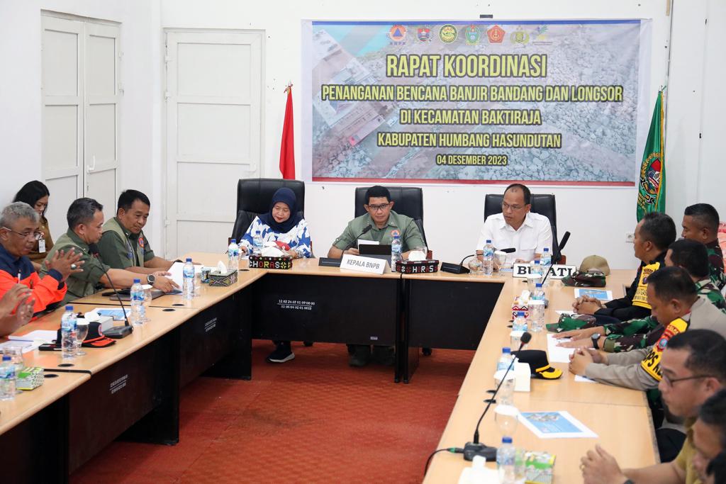 Kepala BNPB Letjen TNI Suharyanto SSos MM (kemeja dan rompi hijau) memberikan arahan dalam Rapat Koordinasi Penanganan Bencana Banjir Bandang dan Tanah Longsor di Kecamatan Baktiraja, Kabupaten Humbahas yang digelar di Kantor Bupati Humbahas, Provinsi Sumut, Senin (4/12/2023). (Dok/BNPB)