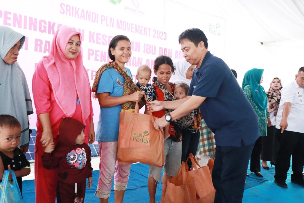 General Manager PLN UIP Sumbagut Hening Kyat Pamungkas serahkan bingkisan bagi peserta Peningkatan Kesehatan Ibu dan Anak Dalam Rangka Penurunan Anak Stunting di areal Mini Soccer, Jalan Ngumban Surbakti, Kecamatan Medan Selayang, Rabu (6/12/2022).