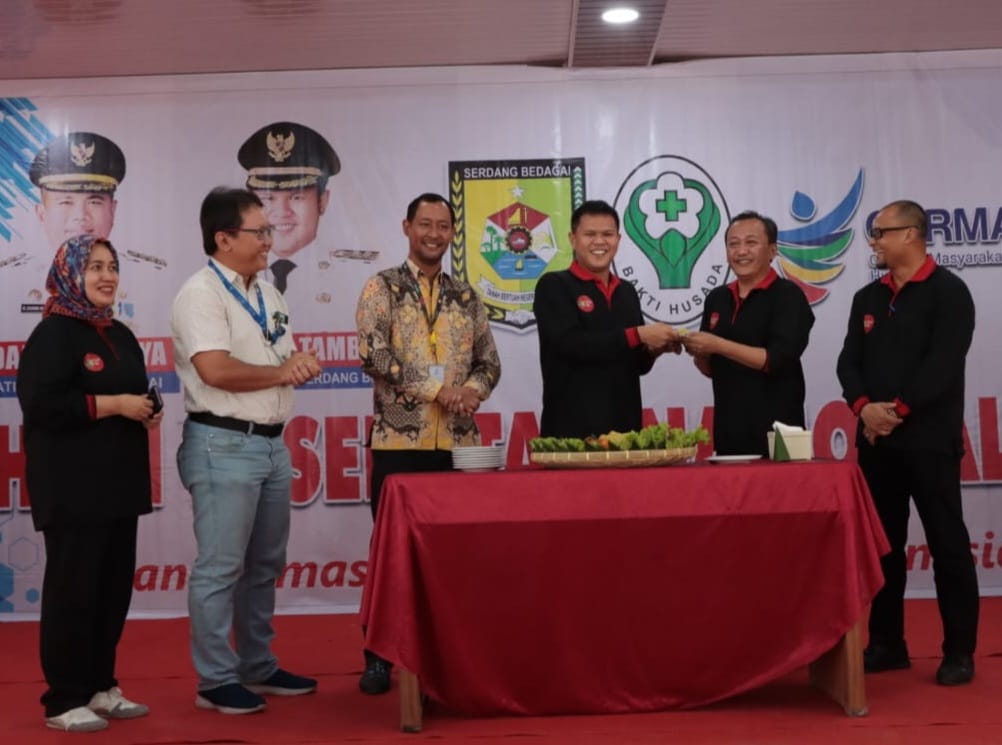 Wakil Bupati Sergai H Adlin Tambunan memotong tumpeng dan  menyerahkan kepada Kadis Kesehatan Sergai dr Yonly Boelian Dachban pada peringatan HKN ke-59, Rabu (6/12/2023). (Dok/Kominfo Sergai)