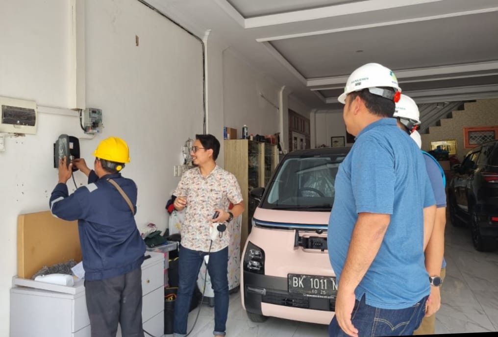Simulasi petugas PLN melakukan pengecasan mobil listrik menggunakan home charging di salah satu rumah pemilik kendaraan listrik di Kota Medan.