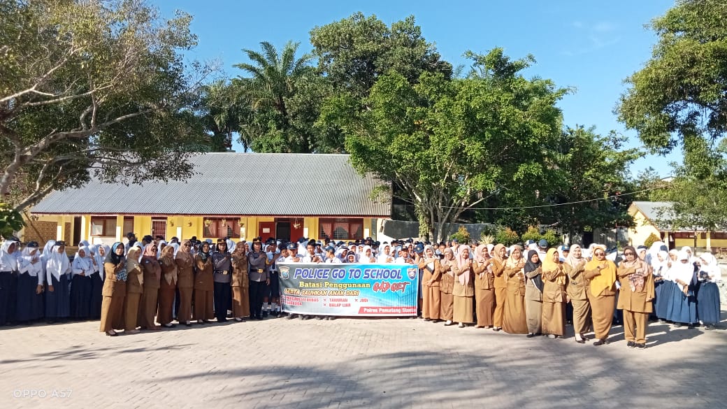 Kasat Binmas Polres Pematangsiantar AKP foto bersama dengan guru dan siswa/i usai  penyuluhan police go to school di SMP Negeri 2 di Jalan Rajamin Purba, Senin (11/12/2023). (Dok/Humas Polres Pematangsiantar)