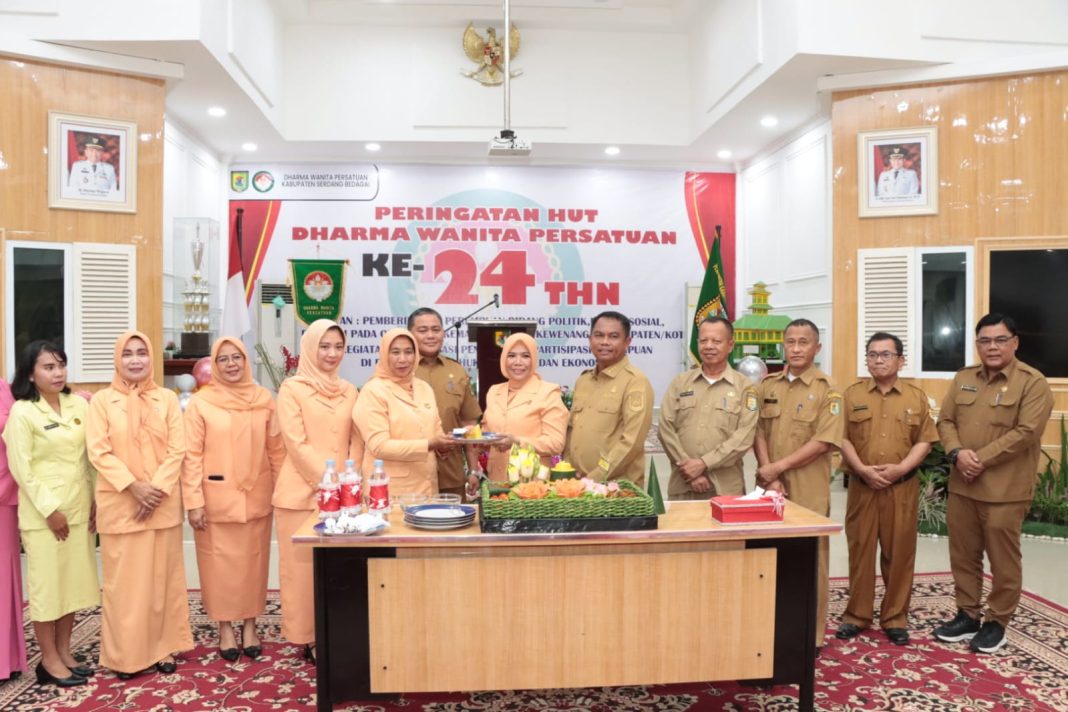 Penasehat DWP Kabupaten Sergai Ny Rosmaida Darma Wijaya disaksikan Bupati H Darma Wijaya memotong tumpeng pada peringatan HUT ke-24 DWP Kabupaten Sergai, Selasa (12/12/2023). (Dok/Kominfo Sergai)