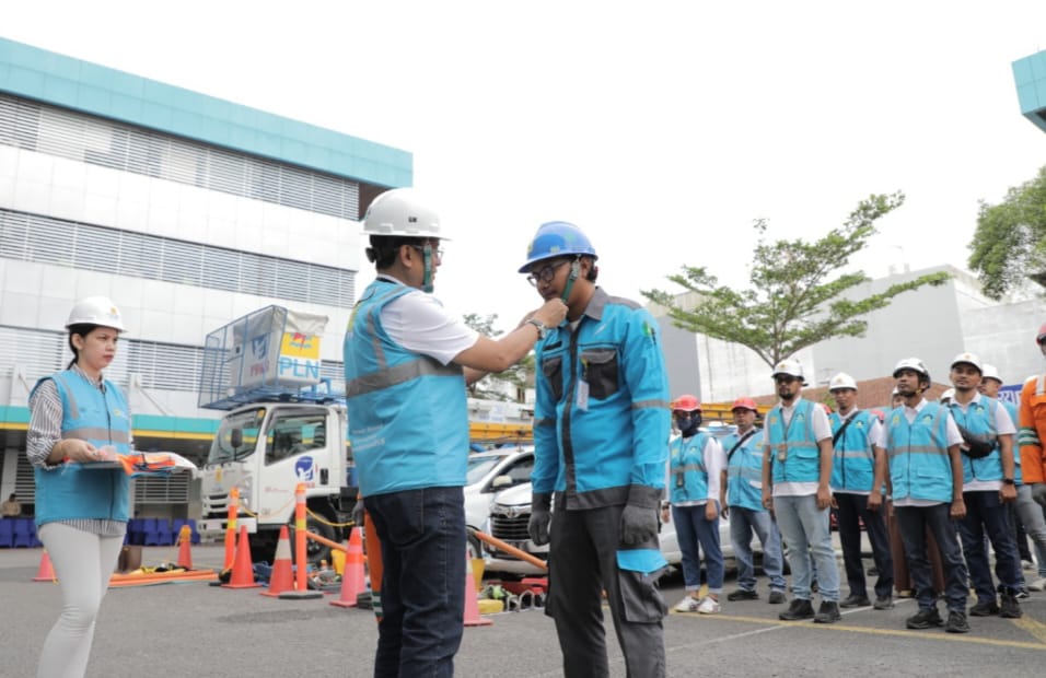 General Manager PLN UID Sumut Awaluddin Hafid melakukan pemasangan helm kepada petugas pelayanan teknik pada apel siaga kelistrikan Natal dan Tahun Baru 2024, Rabu (13/12/2023). (Dok/PLN)