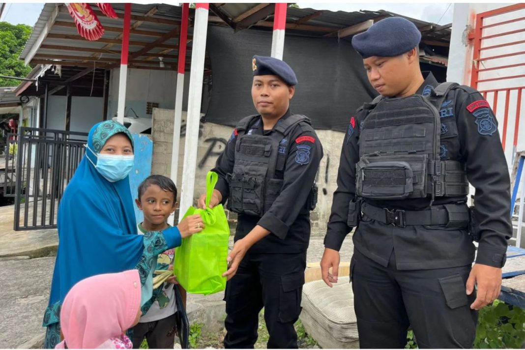 Satuan Brimob Polda Kaltim melalui Batalyon A Pelopor memberikan susu formula untuk anak-anak di Jalan Yos Sudarso, Kelurahan Prapatan, Kota Balikpapan, Minggu (17/12/2023).