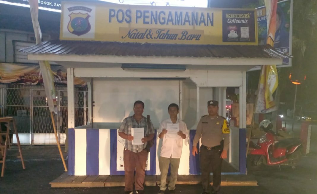 Petugas kepolisian saat mengecek kesiapan pendirian pos pengamanan di Jalan Gereja Simpang Empat Kota Pematangsiantar, Selasa (19/12/2023). (Dok/Humas Polres Pematangsiantar)