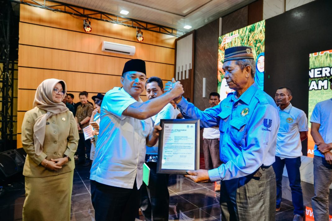 Bupati Zahir memberikan sertifikat Roundtable on Sustainable Palm Oil (RSPO), KUR Pertanian dan Kartu Tani untuk mempermudah akses dalam mendapatkan keperluan pertanian di Pendopo Perjuangan, Desa Empat Negeri, Kecamatan Datuk Lima Puluh, Selasa (19/12/2023). (Dok/Kominfo Batubara)