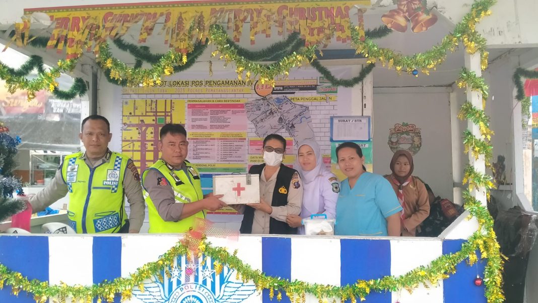 Kasidokkes Polres Pematangsiantar Selfi Diana memberikan kotak medis kepada personel usai mengecek kesehatan petugas yang berjaga dalam pengamanan Ops Lilin Toba 2023 di Pospam dan Posyan di jalur Kota Pematangsiantar, Jumat (22/12/2023). (Dok/Humas Polres Pematangsiantar)