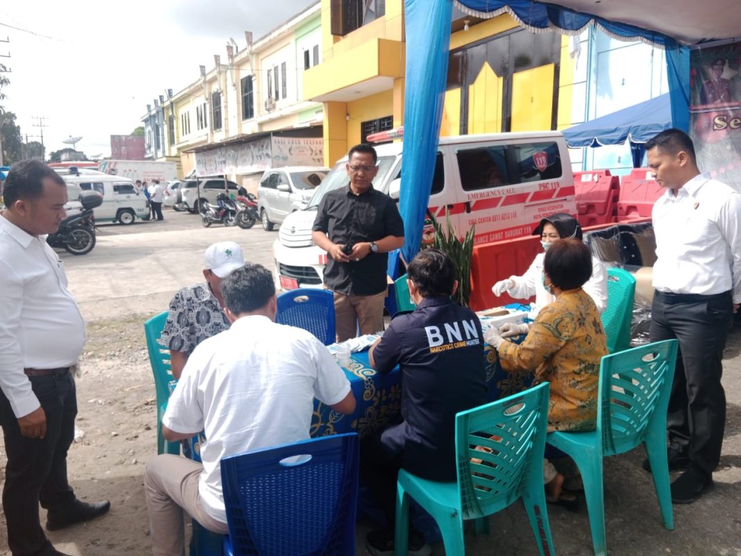 Kasat Resnarkoba Polres Pematangsiantar AKP JH Pasaribu (kemeja hitam), menyaksikan petugas melakukan pemeriksaan tes urine terhadap supir bus di Jalan Medan Simpang Sigagak, Kecamatan Siantar Martoba, Minggu (24/12/2023). (Dok/Humas Polres Pematangsiantar)