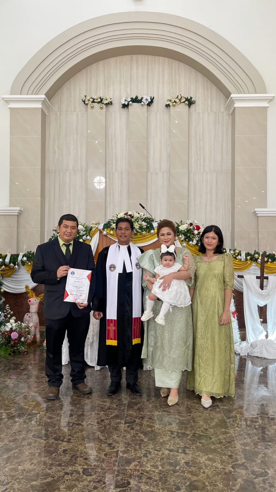 Zevannya Bukit bersama kedua orang tua dan kakaknya Keisha Bukit foto bersama dengan Pdt John Terkelin Ginting MA MTh usai menerima baptisan kudus di GBKP Setia Budi Medan, Selasa (26/12/2023).