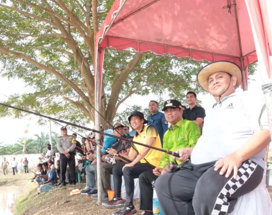 Bupati Sergai H Darma Wijaya bersama Kapolres AKBP Oxy Yudha Pratesta memancing ikan pada gelaran lomba memancing menyemarakkan Hari Jadi Sergai ke-20, Jumat (5/1/2024). (Dok/Kominfo Sergai)