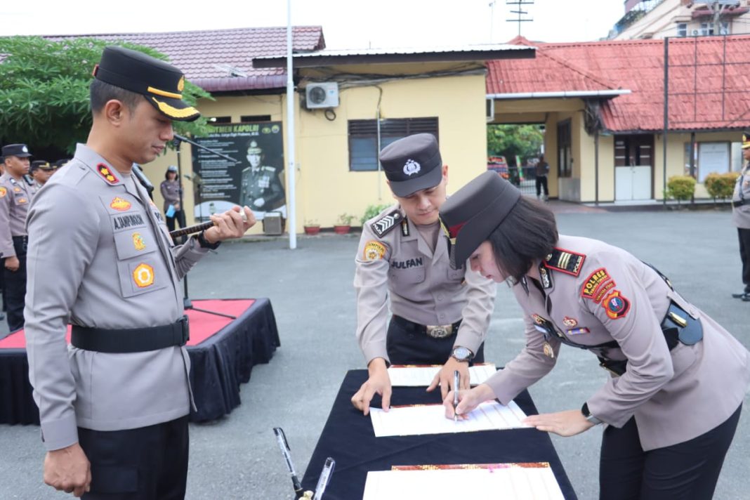 Kapolres AKBP Andreas LJ Tampubolon menyaksikan AKP Agnis Juwita saat menandatangani berkas sertijab, di halaman Mapolres Tebingtinggi, Jalan Pahlawan, Kamis (11/1/2024). (Dok/Humas Polres Tebingtinggi)