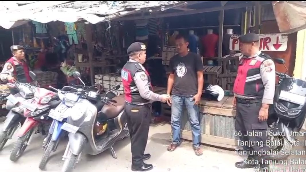 Personel Sat Samapta Polres Tanjungbalai menyambangi pengelola Parkir sepeda motor di Jalan Tengku Umar Kecamatan Tanjungbalai Selatan, Rabu (24/1/2024).