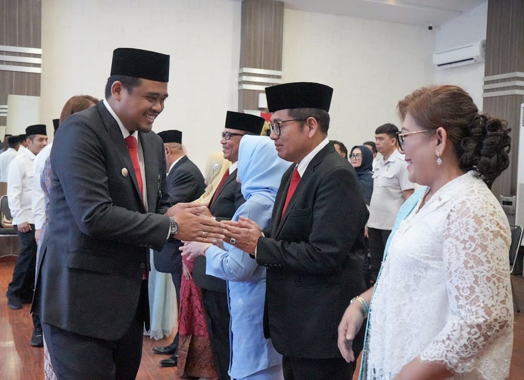 Wali Kota Medan Bobby Nasution bersalaman dengan Suryadi Panjaitan usai melantik dan mengambil sumpah empat Pimpinan Tinggi Pratama, di Ruang Rapat III Kantor Wali Kota Medan, Rabu (24/1/2024). (Dok/Kominfo Medan)