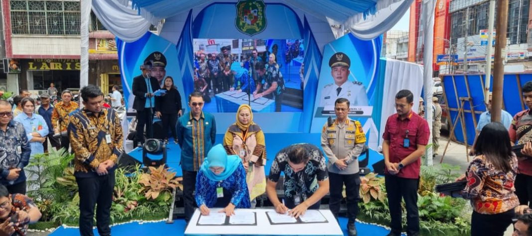 Manager PLN UP3 Medan Ricki Yakop (kanan) bersama Kepala Dinas PMPTSP Kota Medan Nurbaiti Harahap melakukan penandatanganan penyedia layanan dalam Mal Pelayanan Publik Kota Medan disaksikan Wali Kota Medan Bobby Nasution (paling kiri), Kamis (25/1/2024). (Dok/PLN)