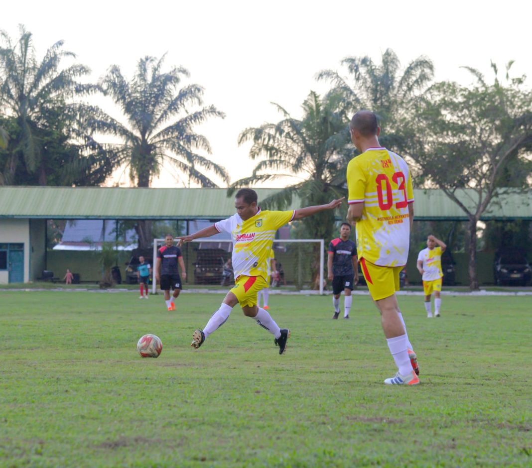 Bupati Sergai H Darma Wijaya disaksikan Kapolres Sergai AKBP Oxy Yudha Pratesta melepas tendangan keras saat memperkuat Tim Forkopimda Sergai dalam laga persahabatan melawan tim FC Legend MK, Jumat (26/1/2024). (Dok/PWI Sergai)