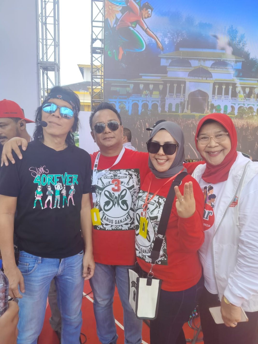 Pembina Relawan Arus Ganjar Dr Hj Fitriani Manurung MPd, Ketua Relawan Arus Ganjar Sumut Ir Romi HS dan Meinarti Bangun foto bersama salah satu personil Slank di Istana Maimun, Jalan Brigjen Katamso, Kota Medan, Provinsi Sumut, Minggu (28/1/2024).