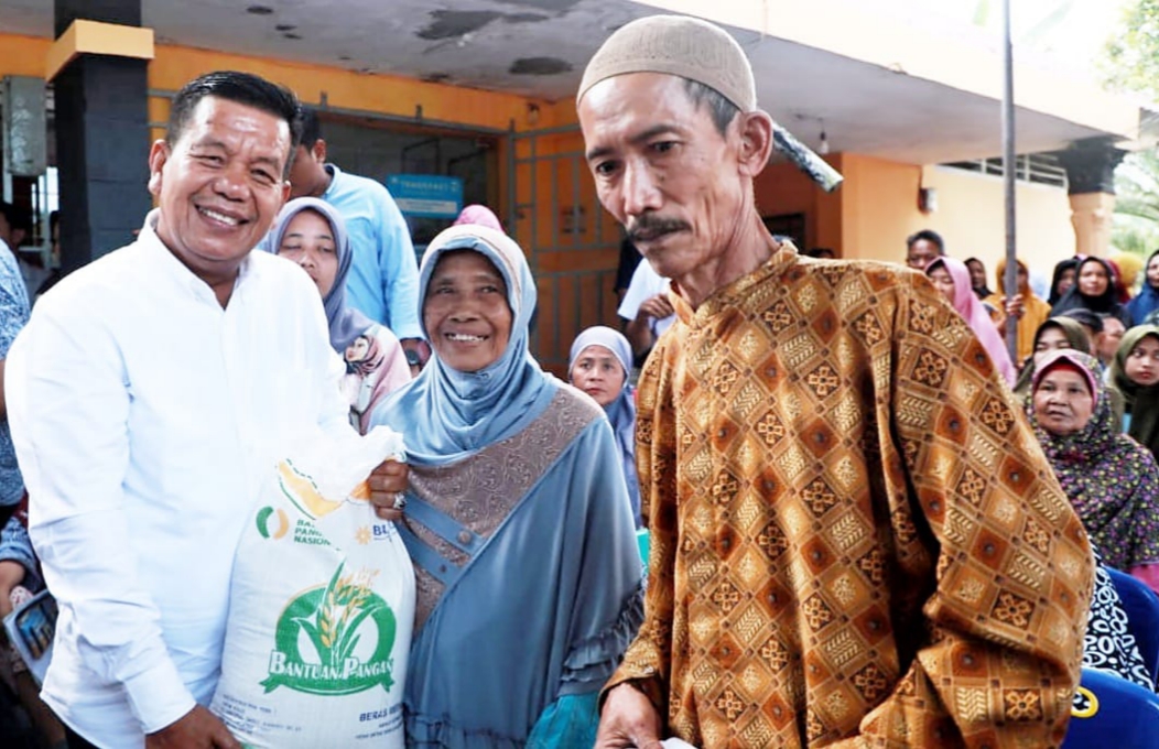 Bupati Simalungun Radiapoh Hasiholan Sinaga (kiri) menyalurkan bantuan Cadangan Pangan Pemerintah kepada masyarakat di Kantor Pos Serbalawan, Rabu (31/1/2024). (Dok/Kominfo Simalungun)