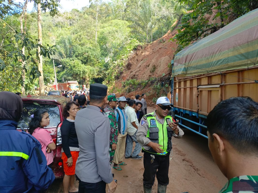 Personel Polisi memantau pembersihan material longsor yang menutup Jalan Lintas Tarutung-Sibolga, KM 31, tepatnya di Kecamatan Adiankoting, Kabupaten Tapanuli Utara. (Dok/Polda Sumut)