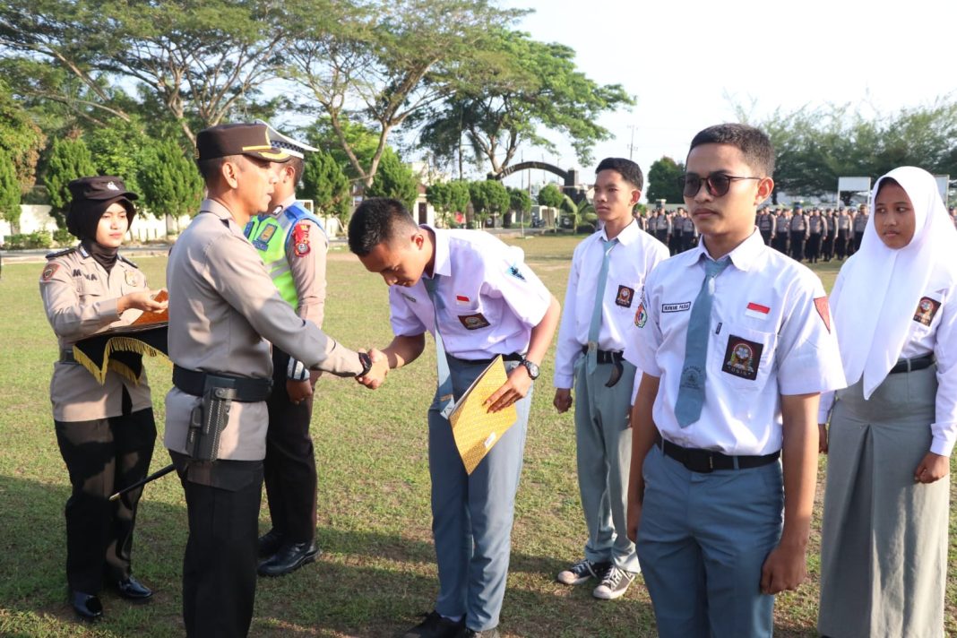 Kapolres Sergai AKBP Oxy Yudha Pratesta menyerahkan hadiah kepada pelajar pemenang lomba fotografi Safety Riding dan Bahaya Narkoba, Senin (5/2/2024). (Dok/Humas Polres Sergai)