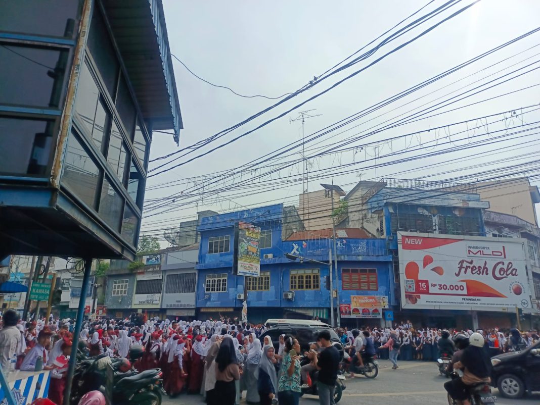 Terlihat pelajar sudah menunggu kedatangan Presiden Jokowi di pinggir Jalan Sudirman, Rabu (7/2/2024).