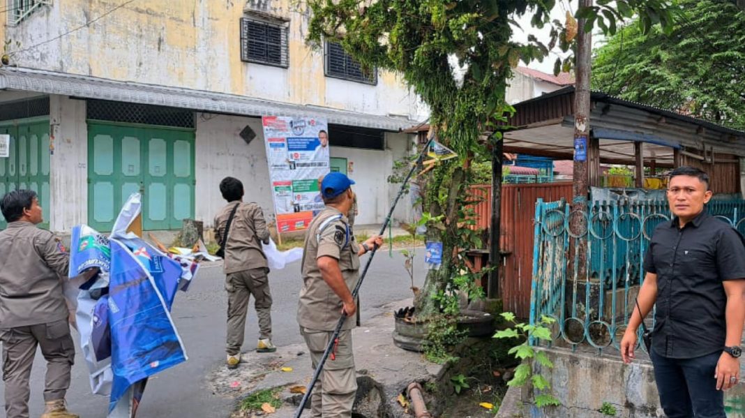 Petugas Satpol PP dan Bawaslu saat menertibkan APK disaat hari pertama masa tenang Pemilu 2024 di tiga lokasi kecamatan di Kota Pematangsiantar, Minggu (11/2/2024). (Dok/Humas Polres Pematangsiantar)