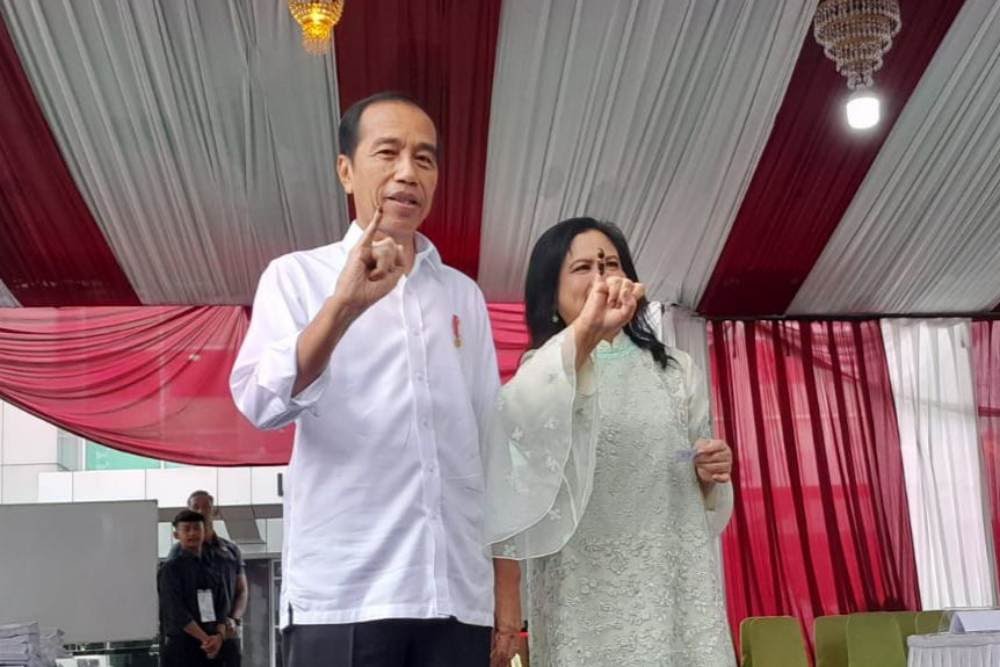 Presiden Jokowi dan Ibu Negara Iriana Joko Widodo menunjukkan jari bertinta, tanda telah menggunakan hak pilihnya di Pemilu 2024.