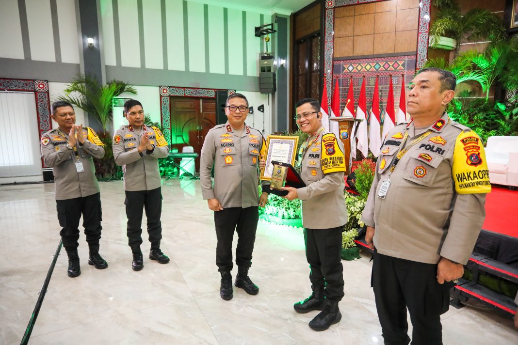 Kapolda Sumut Irjen Pol Agung Setya Imam Effendi menyerahkan piala dan piagam penghargaan kepada Kapolrestabes Medan Kombes Pol Dr Teddy John Sahala Marbun di Gedung Aula Tribrata Polda Sumut, Rabu (13/3/2024). (Dok/Polrestabes Medan)