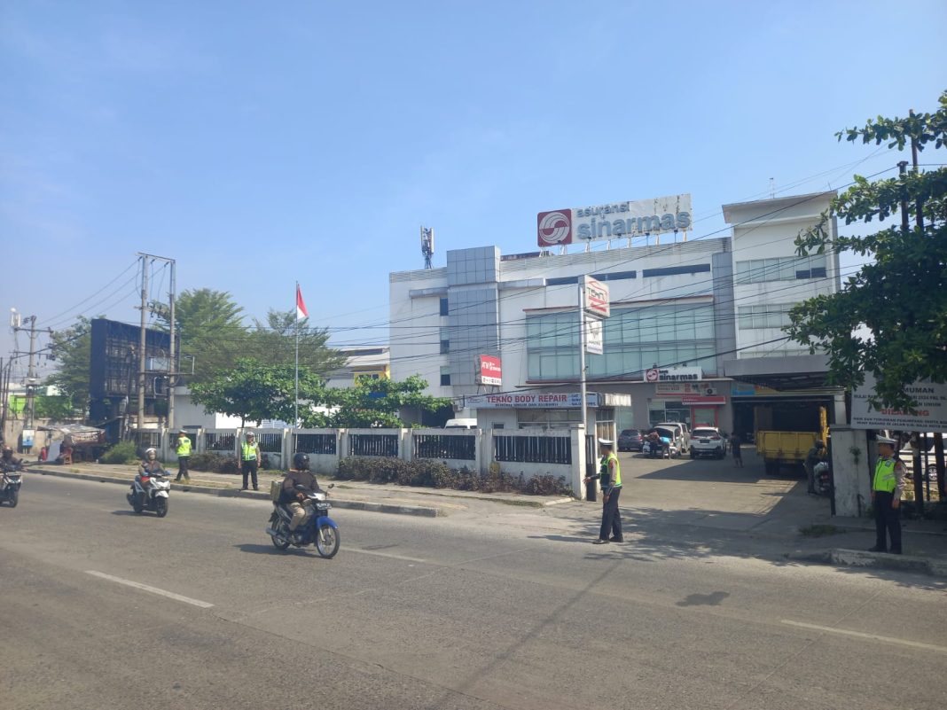 Personel lantas memantau ketertiban pengendara di Simpang Tritura-Jalan Sisingamangara Medan, Jumat (15/3/2024). (Dok/Polda Sumut)