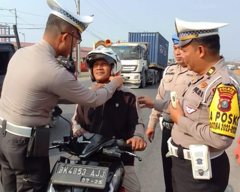 Kasat Lantas Polres Pelabuhan Belawan AKP Pittor Gultom mengedukasi salah seorang pengendara sepeda motor cara menggunakan helm yang benar, Sabtu (16/3/2024).(Dok/Polres Belawan)