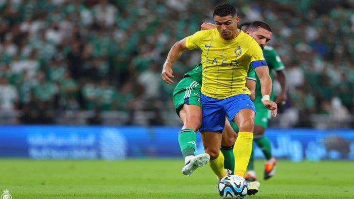 Cristiano Ronaldo berduel dengan pemain tuan rumah dalam pertandingan Al Ahli vs Al Nassr di King Abdullah Sports City, Jeddah, Sabtu (16/03/2024) dini hari WIB. CR7 mengantarkan timnya menang 1-0.