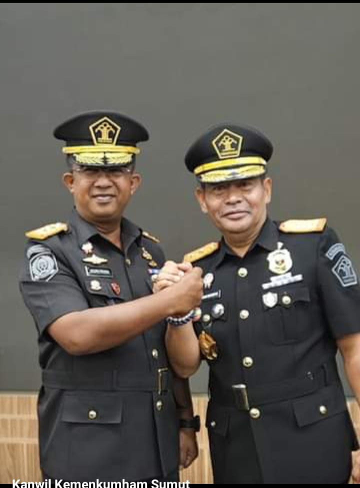 Kakanwil Kemenkumham Sumut yang baru, Anak Agung Gde Krisna salam Komando dengan pejabat lama M Jahari Sitepu, usai pelantikan di Graha Pengayoman, Senin (18/3/2024). (Dok/Humas Kemenkumham Sumut)