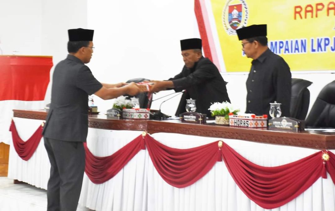 Bupati Humbahas Dosmar Banjarnahor menyampaikan Nota Pengantar LKPj Bupati akhir tahun 2023 kepada Ketua DPRD Ramses Lumban Gaol dalam rapat paripurna di kantor dewan, Komplek Perkantoran Tano Tubu, Doloksanggul, Selasa (26/3/2024). (Dok/Kominfo Humbahas)