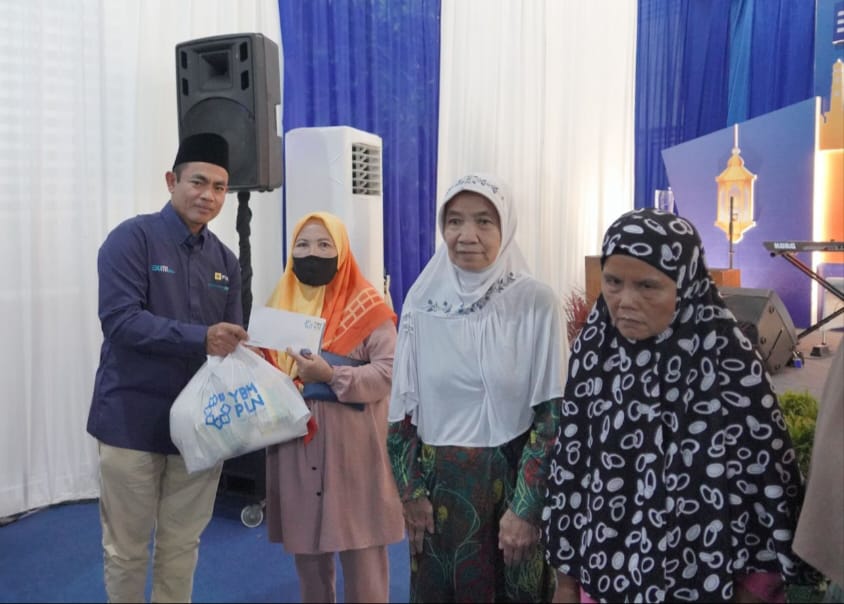 General Manager PLN UID Sumut Saleh Siswanto menyerahkan paket sembako kepada kaum dhuafa yang berada di sekitar kantor PLN UID Sumut, Selasa (26/3/2024). (Dok/PLN)