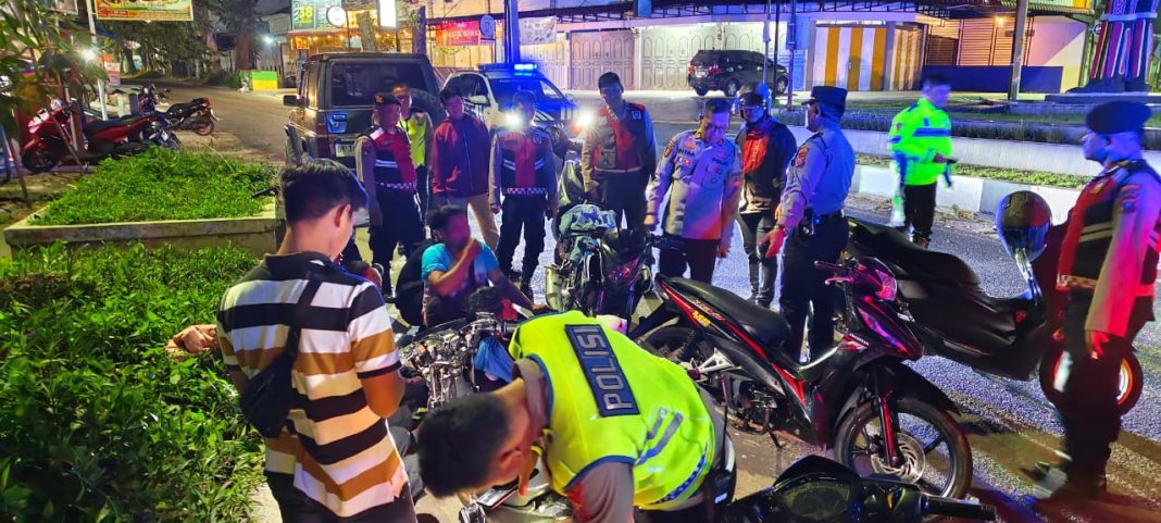 Petugas kepolisian saat mengamankan sepeda motor yang menggunakan knalpot blong saat operasi KRYD di beberapa ruas jalan di Kota Pematangsiantar, Minggu (31/3/2024) dini hari. (Dok/Humas Polres Pematangsiantar)