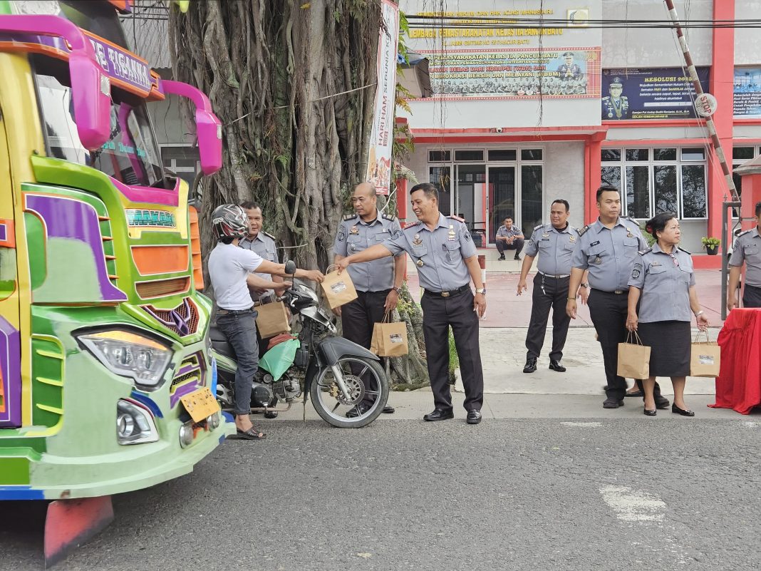 Kepala Lapas Kelas IIA Pancurbatu Haposan Silalahi AmdIP SSos memberikan takjil kepada warga sekitar di depan Kantor Lapas Kelas IIA Pancurbatu, Jalan Jamin Ginting, Kecamatan Pancurbatu, Senin (1/4/2024). (Dok/Lapas Pancurbatu)