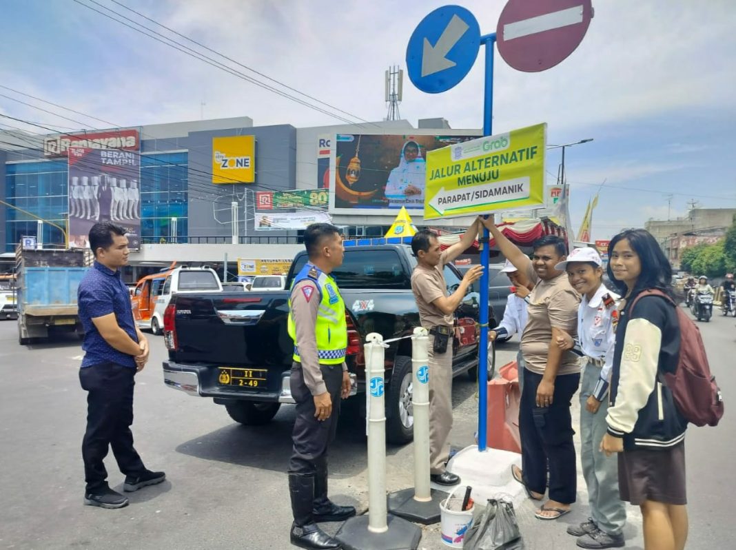 Petugas saat memasang petunjuk arah jalur alternatif di beberapa titik perlintasan jalan yang dilalui para pemudik menghindari kemacetan arus lalulintas saat pelaksanaan Ops Ketupat Toba 2024 di Kota Pematangsiantar, Minggu (7/4/2024). (Dok/Humas Polres Pematangsiantar)